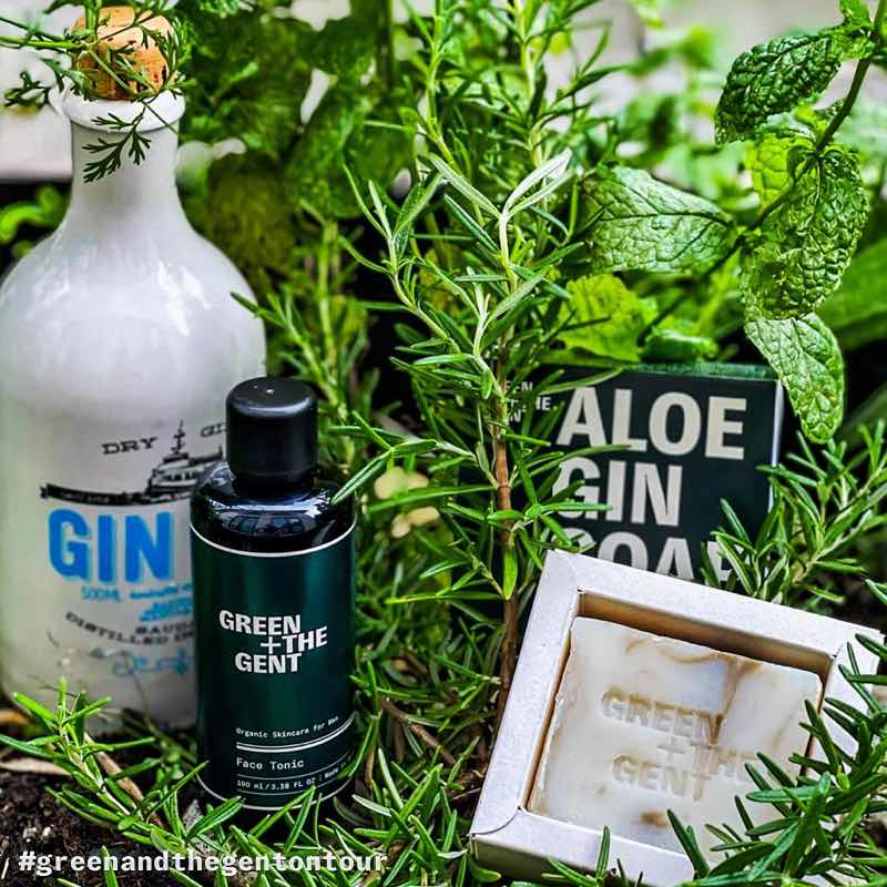 Aloe Gin Soap und Face Tonic von GREEN + THE GENT zusammen mit einer Gin-Flasche in einem Kräuterbeet
